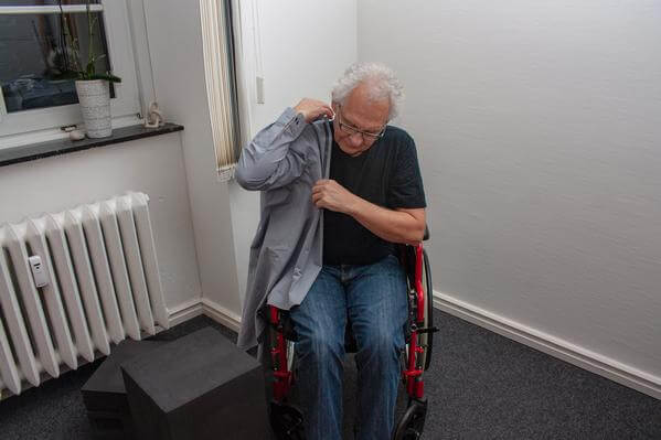 die Schulterpartie muss passen - mit beiden Händen den Ärmel bis zur Schulter hochziehen.